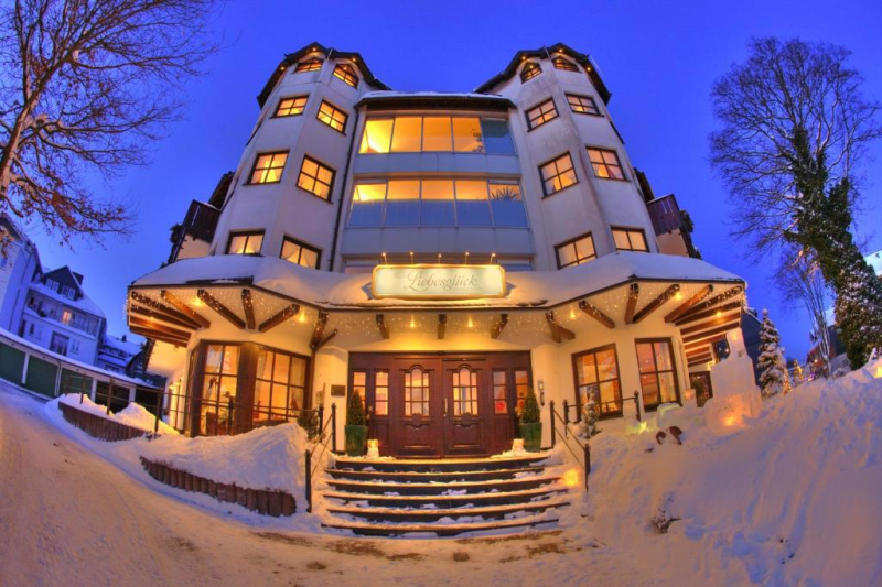 Verlicht hotel in de avond in de sneeuw in Winterberg