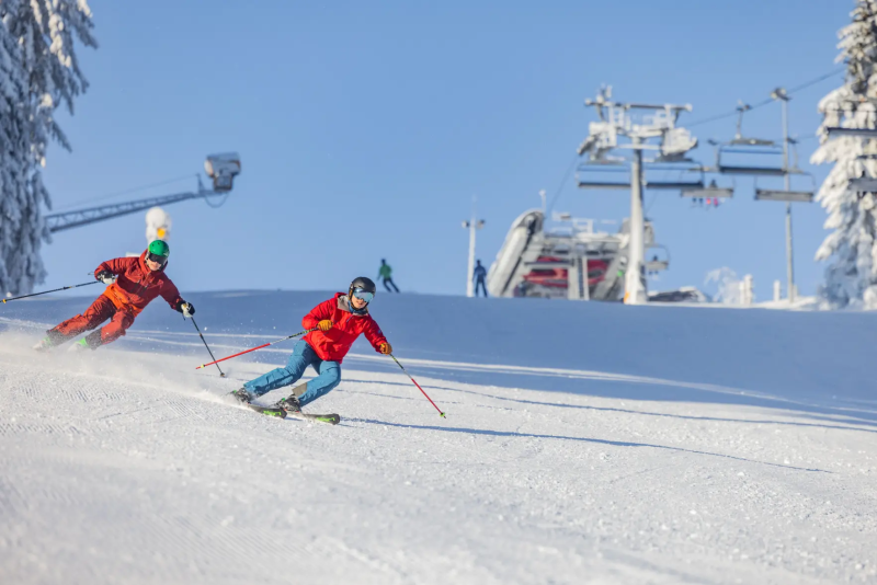 Skiër in het rood op de piste in Winterberg