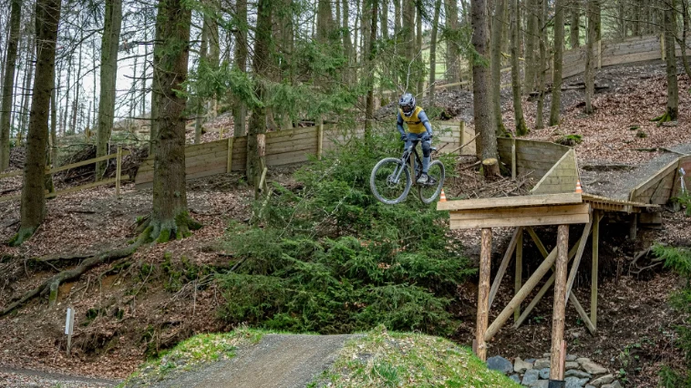 Mountainbiker maakt een sprong in het bikepark van Winterberg