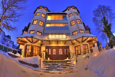 Verlicht hotel in de avond in de sneeuw in Winterberg