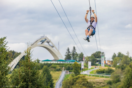 Persoon aan de zipline boven een brug in Winterberg